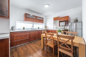 a kitchen with wooden cabinets and a wooden table and chairs at Chata Majocka Martin Strane, Ferrata in Martin