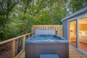 a hot tub on the deck of a house at Hot Tub Firepit Dreams Streamside Hochatown in Broken Bow