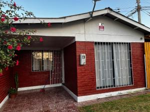 a red brick house with a door and windows at Casa familiar excelente ubicación in La Serena