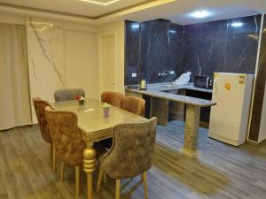 a room with a table and chairs and a refrigerator at Gulf Suites Cairo in Cairo