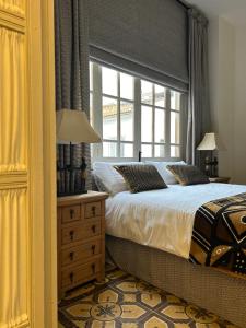 a bedroom with a large bed and a window at Casona de Santa Ana in Cuevas Bajas