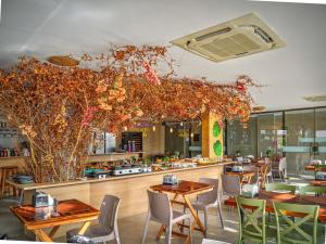 a restaurant with wooden tables and chairs and plants at Porto de Galinhas PORTO EXCLUSIVE BY AFT in Porto De Galinhas