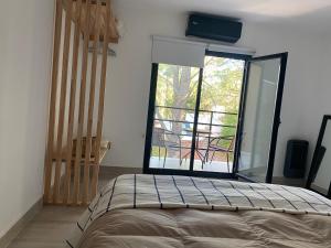 a bedroom with a bed and a large glass window at Senderos del Mar II in Monte Hermoso