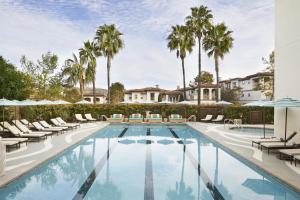a swimming pool with lounge chairs and palm trees at Waldorf Astoria Monarch Beach Resort & Club in Dana Point