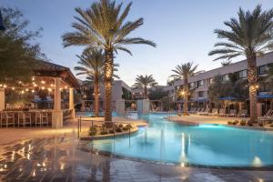 a large swimming pool with palm trees in a resort at The Scottsdale Resort & Spa, Curio Collection by Hilton in Scottsdale