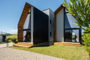 a house with a black and white facade at Cabanas Horizonte Cambará Solare in Cambará