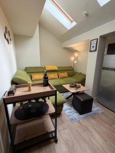 a living room with a green couch and a table at Chamkoria Forest apartment in Borovets