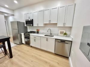 a kitchen with white cabinets and stainless steel appliances at 241- Convenient City Stay in Hoboken +23 photos