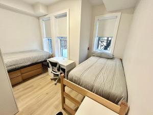 a bedroom with a bed and a desk and two windows at 241- Convenient City Stay in Hoboken
