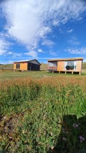 a couple of buildings sitting in a field at Cabañas 2 Aliwen Lonquimay in Lonquimay