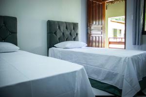 two beds sitting next to each other in a room at Pousada da Isa in Quatro Barras