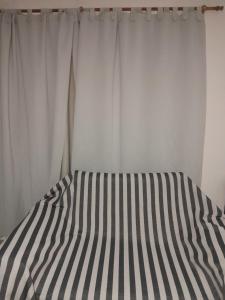 a bed with a black and white striped sheet at Bienvenidos a mi casa in Chajarí