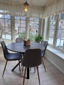 a dining room table and chairs in a room with windows at Stryn - house by the river in Stryn