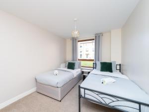 a room with two beds and a couch at Crawley 2 bed flat with Parking in Crawley
