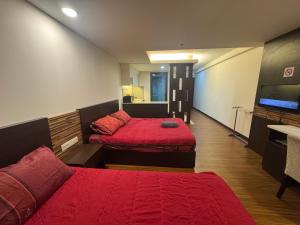 a hotel room with two beds and a television at EasyStay Studio Apartment KBCP in Kota Bharu
