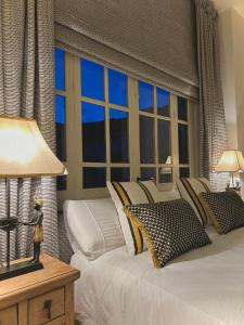a bedroom with a white bed with a large window at Casona de Santa Ana in Cuevas Bajas