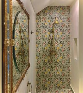 a bathroom with a shower with a floral wallpaper at Casona de Santa Ana in Cuevas Bajas +106 photos