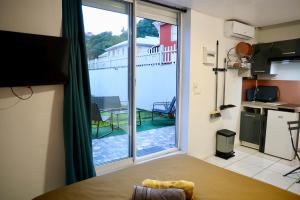 a kitchen with a large window with a view of a patio at Domaine Maud-Jardin de Maud ! 100m plage in Saint-Pierre