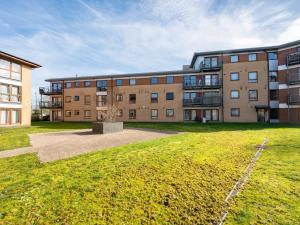 an apartment building with a grassy yard in front of it at Crawley 2 bed flat with Parking in Crawley