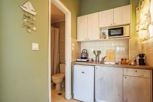 a small kitchen with a sink and a microwave at Thalassa Apartments & Studios in Kavos