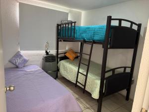 ein Schlafzimmer mit zwei Etagenbetten und einem Bett in der Unterkunft Casa SkiPhoe in Panchimalco + 32 Fotos