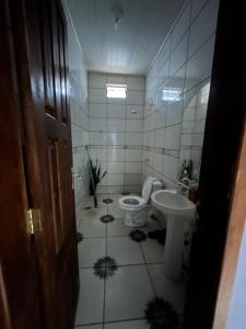 a bathroom with a toilet and a sink at Casa Takahashi in Ariquemes