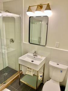 a bathroom with a sink and a toilet and a mirror at Far Out Motel in Starkville