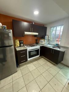 eine Küche mit Kühlschrank und Herd Oberer Backofen in der Unterkunft Casa SkiPhoe in Panchimalco