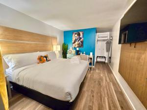 a bedroom with a large bed and blue walls at Far Out Motel in Starkville