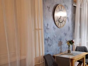 a dining room with a table and a clock on the wall at Apartmán CENTRAL, near the center, self check in 24 h, free parking in Banská Bystrica
