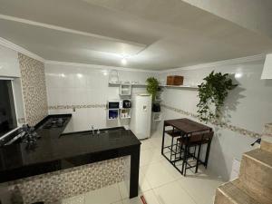 a kitchen with a counter and a refrigerator and a table at Casa Canto do Rio in Socorro
