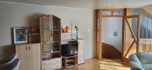 a living room with a entertainment center with a television at Lukács Ház in Bük