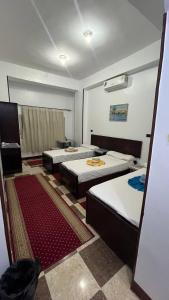 a room with three beds in a room at Bayt Zaina Nile View in Aswan +44 photos