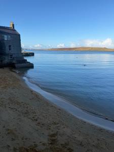 ein Haus am Ufer eines Gewässers in der Unterkunft Fairview in Lerwick