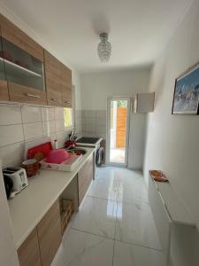 a white kitchen with a sink and a dishwasher at MaNo Apartman Siófok in Siófok