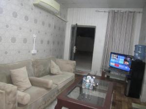 a living room with a couch and a table and a tv at العين الهيلي المصباح ب ب 9 in Al Ain