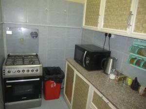 a kitchen with a stove and a microwave at العين الهيلي المصباح ب ب 9 in Al Ain
