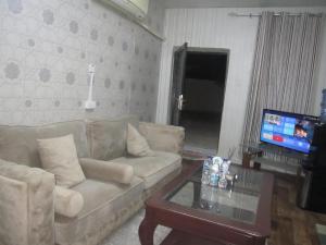 a living room with a couch and a table and a tv at العين الهيلي المصباح ب ب 9 in Al Ain