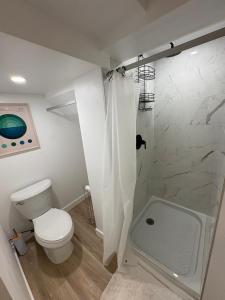 a white bathroom with a toilet and a shower at Private Suite Jones Lake- West Moncton in Moncton