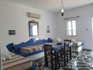 a room with two beds and a table and chairs at Aegean Home - Studios & Apartments in Masouri