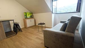 a living room with a couch and a television at Atico moderno en Langreo in Langreo