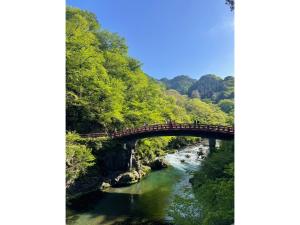 a bridge over a river with people walking on it at SAKURA HOTEL - Vacation STAY 35483v in Hanawadamachi