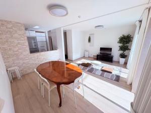 a living room with a table and a couch at SAKURA HOTEL - Vacation STAY 35483v in Hanawadamachi