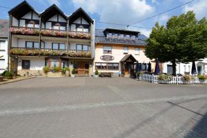 a large building with a courtyard in front of it at Landgasthaus Pension Schmidthöfer in Berschweiler