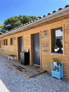 a wooden cabin with a deck and a window at La tranquille marée , à 5 min des plages in Soorts-Hossegor