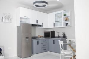 a kitchen with a stainless steel refrigerator and a table at Carrasco Apartamentos in Nagua