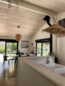 a kitchen with a sink and a dining room at La tranquille marée , à 5 min des plages in Soorts-Hossegor