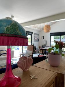 a red lamp sitting on top of a wooden table at La tranquille marée , à 5 min des plages in Soorts-Hossegor +14 photos