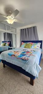 a bed in a room with a ceiling fan at Carrasco Apartamentos in Nagua