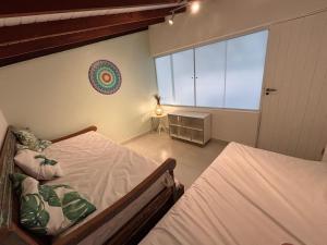 a bedroom with a bed and a large window at Apartamento em Maresias a 100 metros da praia in Maresias +40 photos